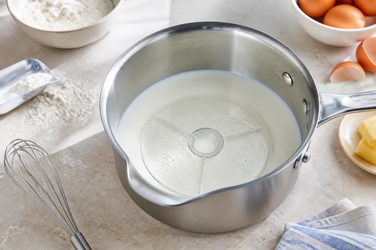 Disque anti-monte-lait en verre posé au fond d&rsquo;une casserole de lait